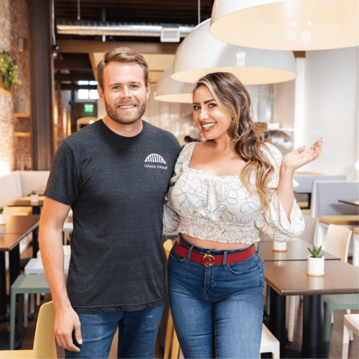 2 people standing next to each other in restaurant